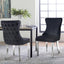 Pair of black velvet Paris dining chairs with polished silver legs in bright dining space.