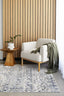  styled in a modern living room with a cream armchair, wooden side table, and green throw, highlighting its soft texture and vibrant patterns.