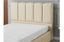 Close-up of Riley beige PU leather bed showing padded vertical headboard panels and soft finish.