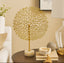 Decorative gold tree sculpture on a table with a neutral background