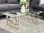 Royale silver frame coffee table with clear glass top styled with black lounge suite.
