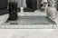 Decorative mirrored tray on a marble surface with decorative items in the background