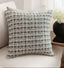 Decorative pillow with a black and white pattern on a white couch.